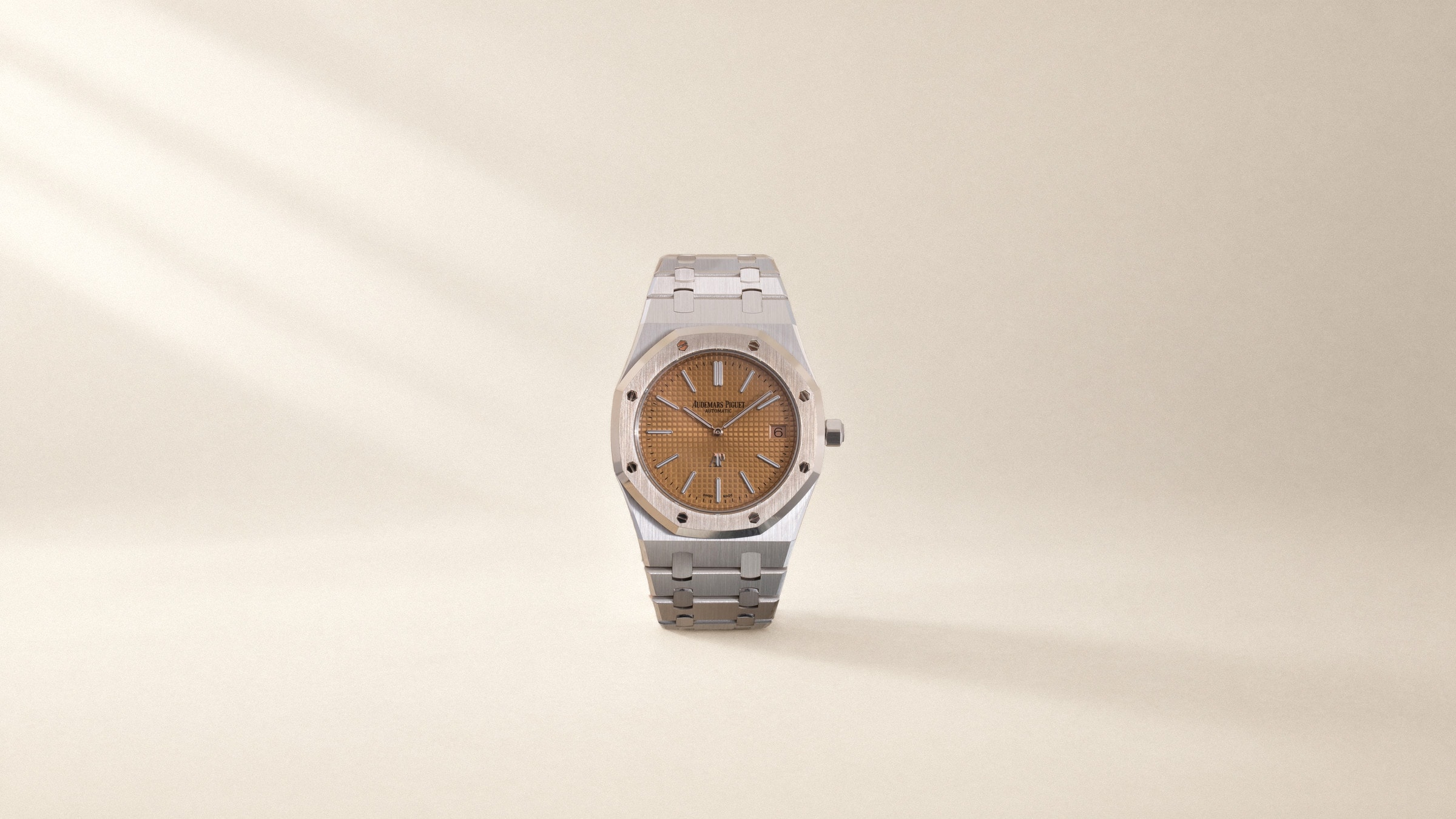 Audemars Piguet Royal Oak Jumbo with a salmon dial, standing on ivory paper in soft daylight